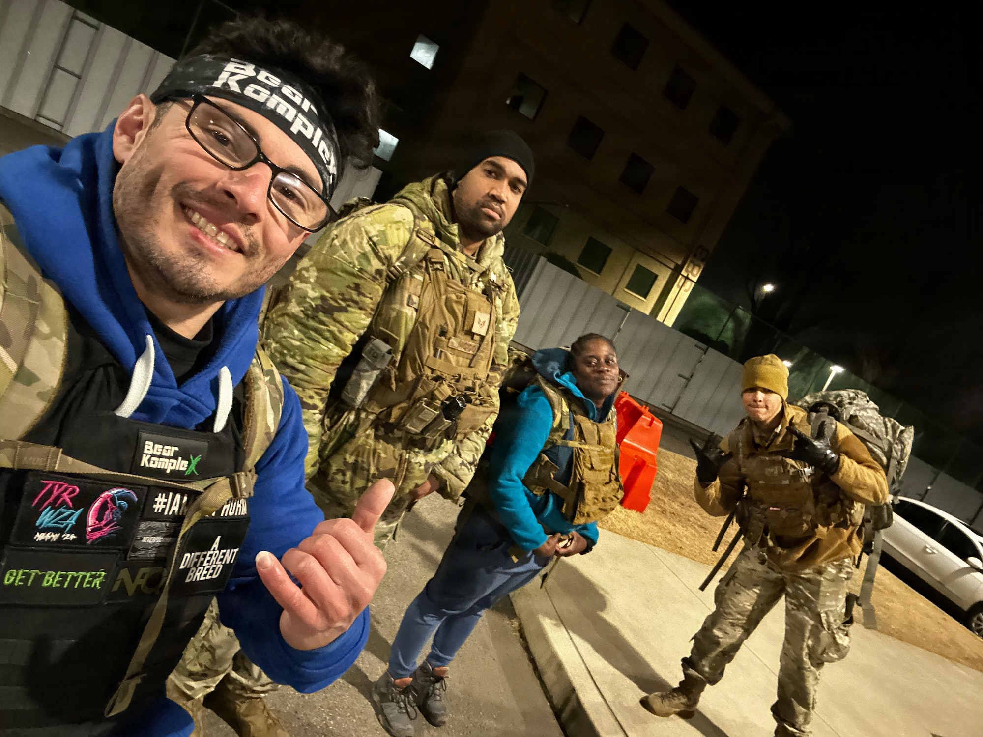 An Airman takes a selfie with other defenders before a nighttime ruck.