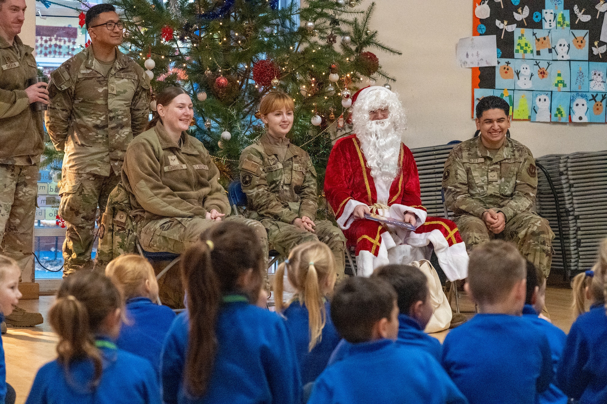 Santa Claus and his helpers assigned to the 420th Munitions Squadron speak with children