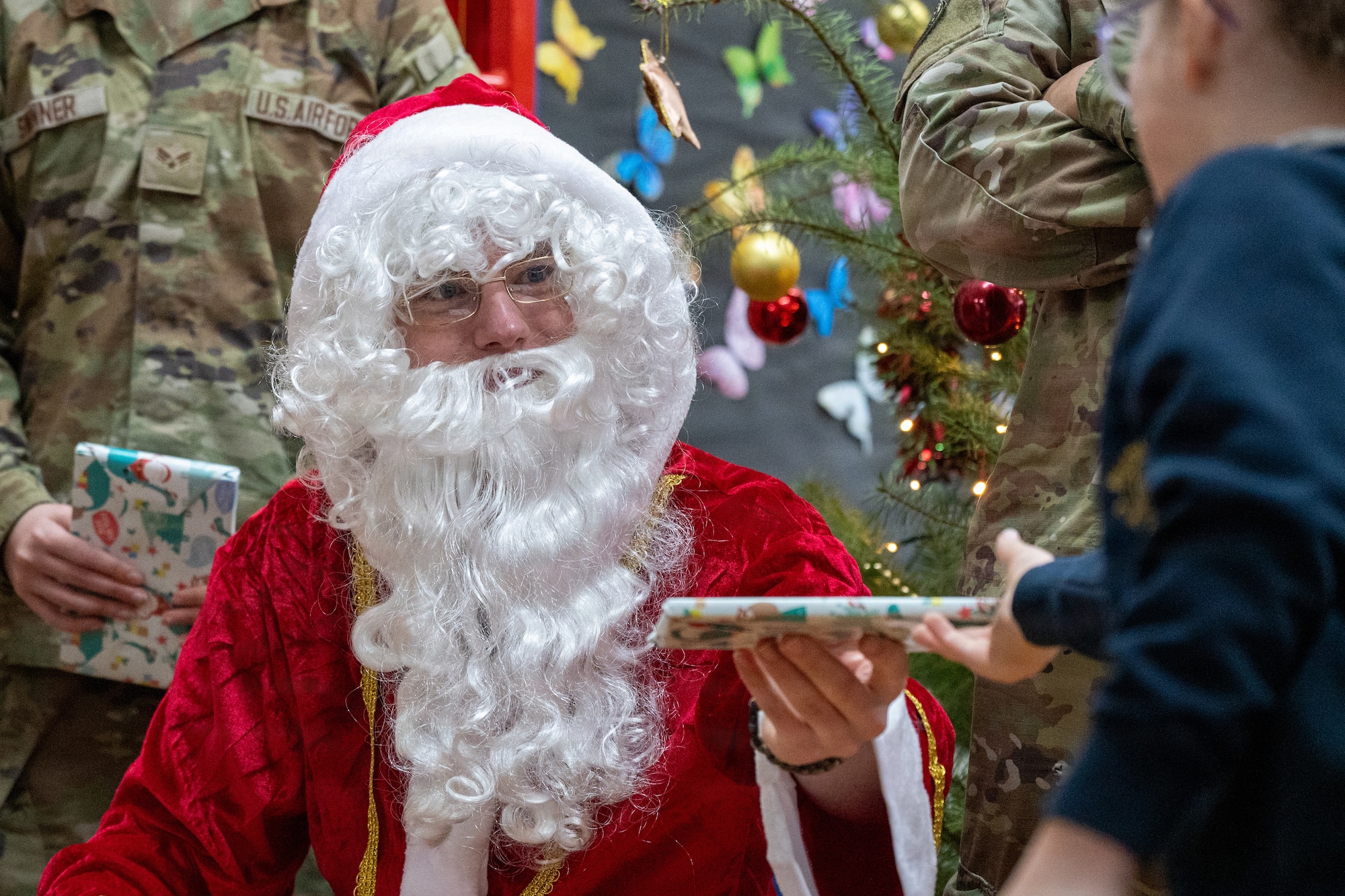 Santa Claus hands a gift to a child
