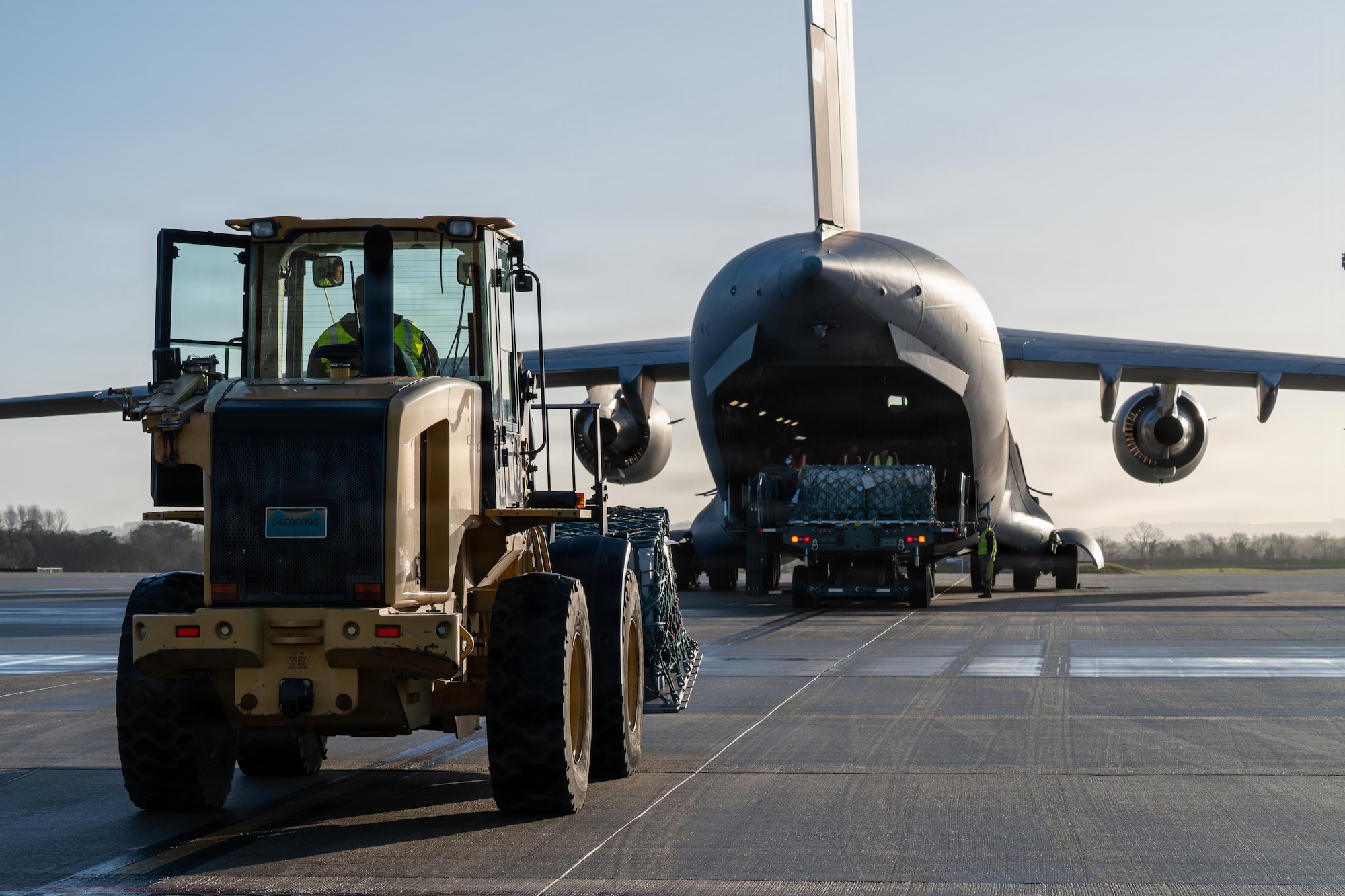 A ground transportation operator prepares to load cargo aboard a Royal Air Force C-17 Globemaster III