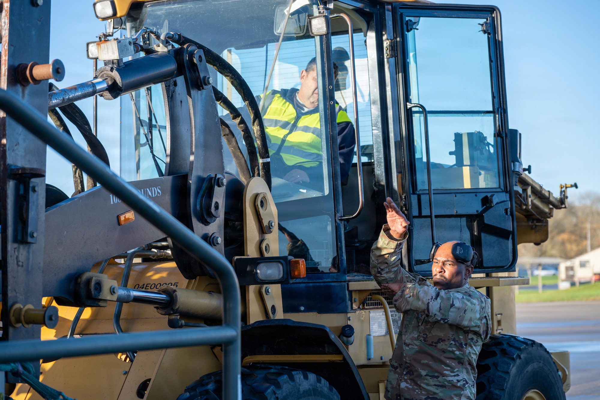 U.S. Air Force Master Sgt. Justin George, 420th Air Base Squadron air operations manager, guides a ground transportation operator during cargo operations