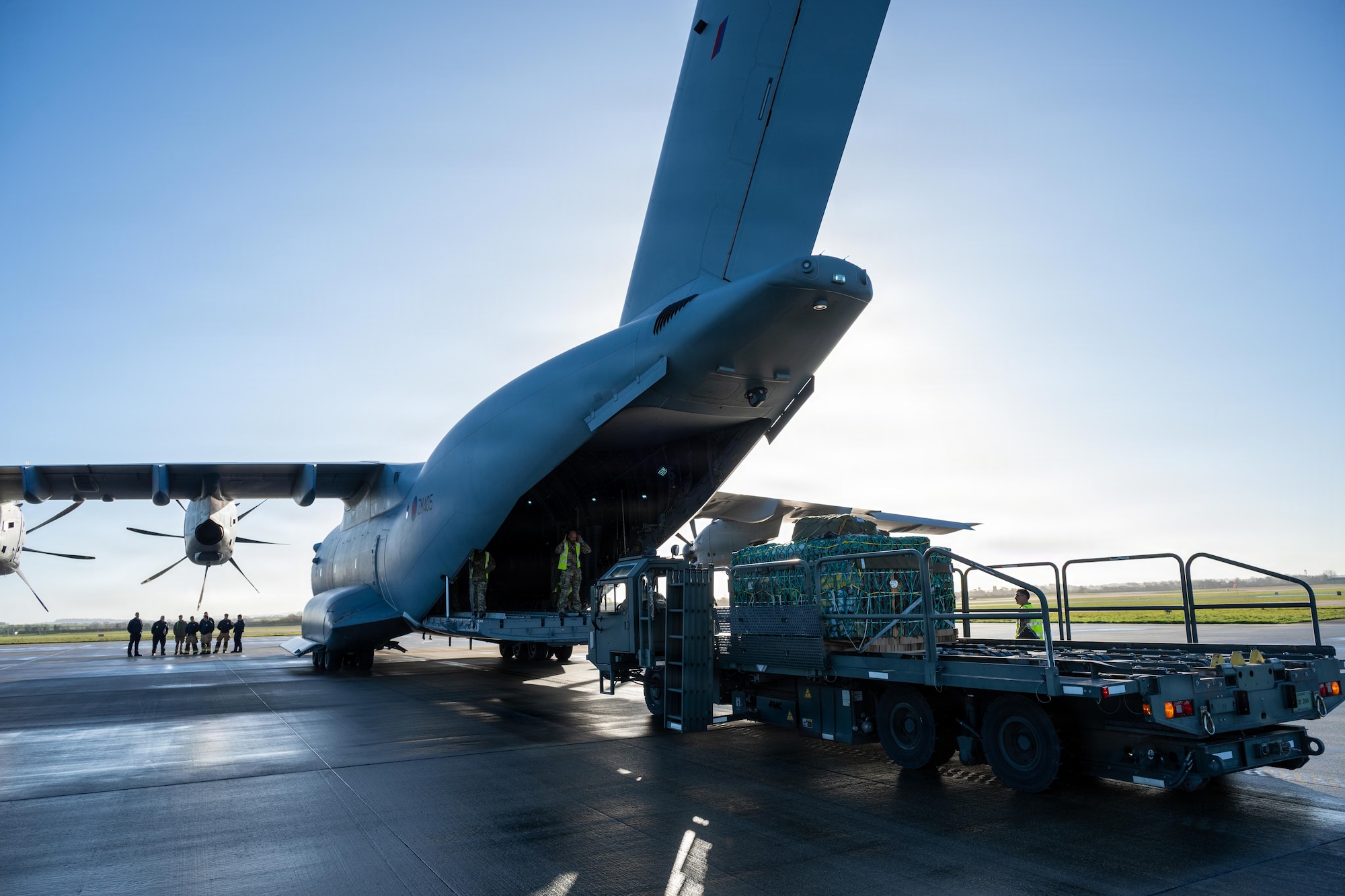 Members of the 420th Air Base Squadron and Royal Air Force Brize Norton prepare to load cargo aboard a C-17 Globemaster III