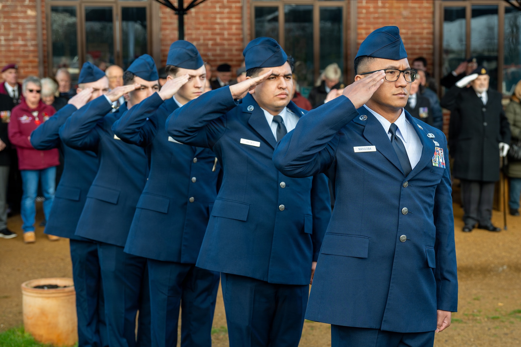 U.S. Air Force Airmen assigned to the 420th Munitions Squadron render salutes during a memorial service