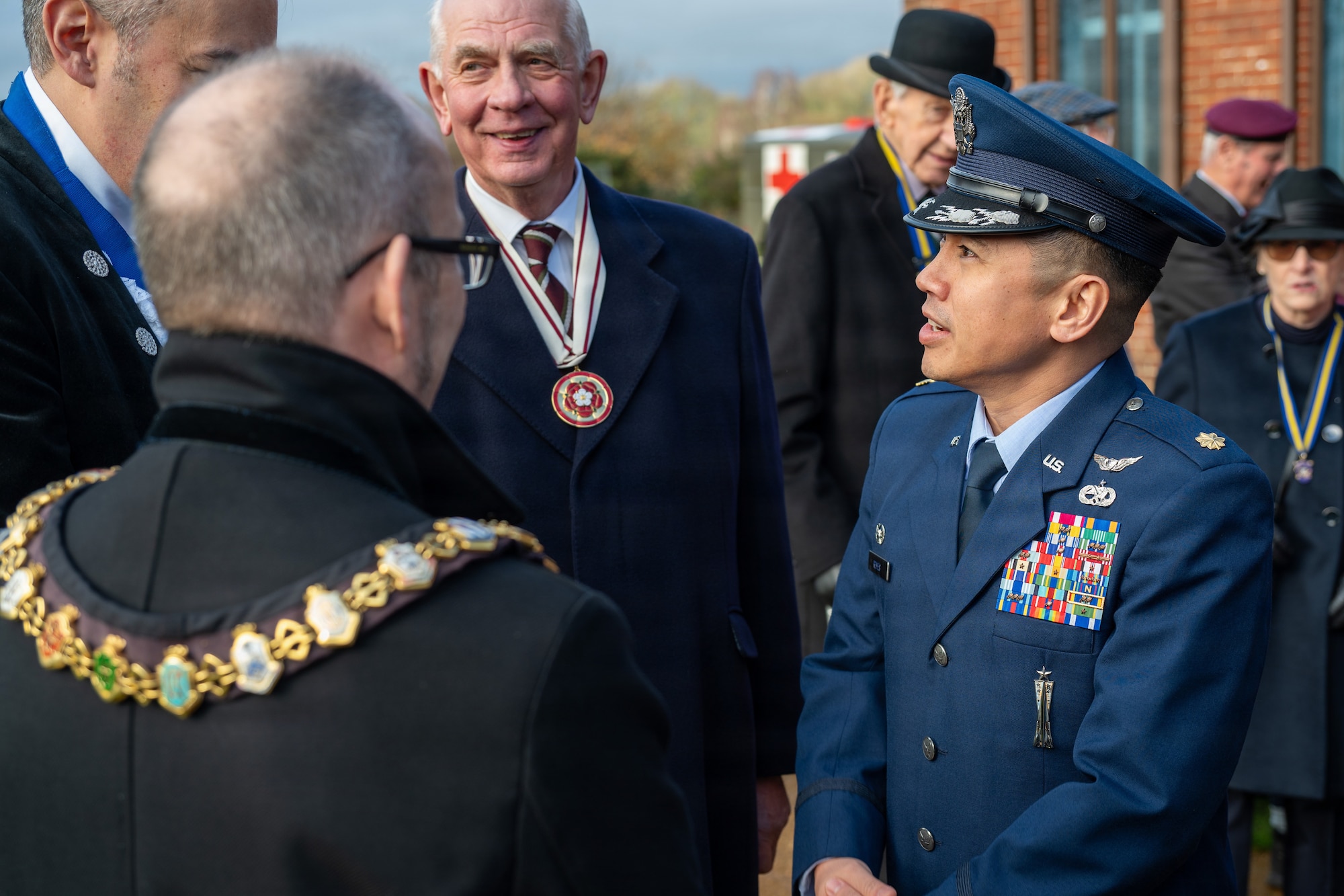 U.S. Air Force Maj. Marques L. Reyes, 420th Munitions Squadron commander, meets with local dignitaries after a memorial service