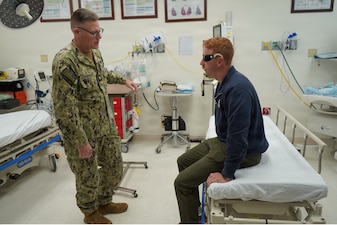 251210-N-FT324-4303. ROTA, Spain (December 10, 2025) – Pictured left, Cmdr. Vincent Ackerman, assigned to Navy Medicine Readiness and Training Command Rota, participated in the Survival, Evasion, Resistance and Escape Phase II reintegration exercise conducted at Naval Station Rota, Spain. As a family medicine physician, Ackerman conducts medical assessment to identify immediate health concerns, and determine appropriate follow-on care on simulated recovered service members. SERE training prepares members to survive isolation, resist exploitation, and safely return to friendly control. (U.S. Navy Photo Taken by Lt. Cmdr. Alicia Sacks)