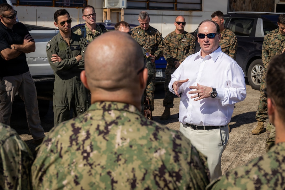 The Honorable John C. Phelan, center, secretary of the Navy, speaks to U.S. Sailors with Electronic Attack Squadron (VAQ) 132 at Jose Aponte de la Torre Airport Ceiba, Puerto Rico, Dec. 24, 2025. U.S. military forces are deployed to the Caribbean in support of the U.S. Southern Command mission, Department of War-directed operations and the president’s priorities to disrupt illicit drug trafficking and protect the homeland. (U.S. Marine Corps photo)