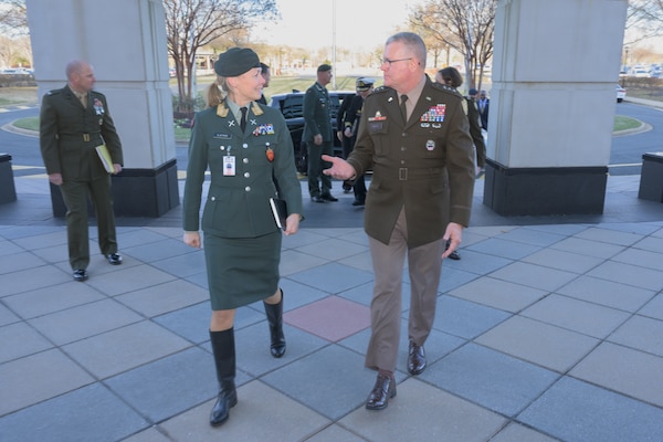 A woman and man in military uniforms walk outside