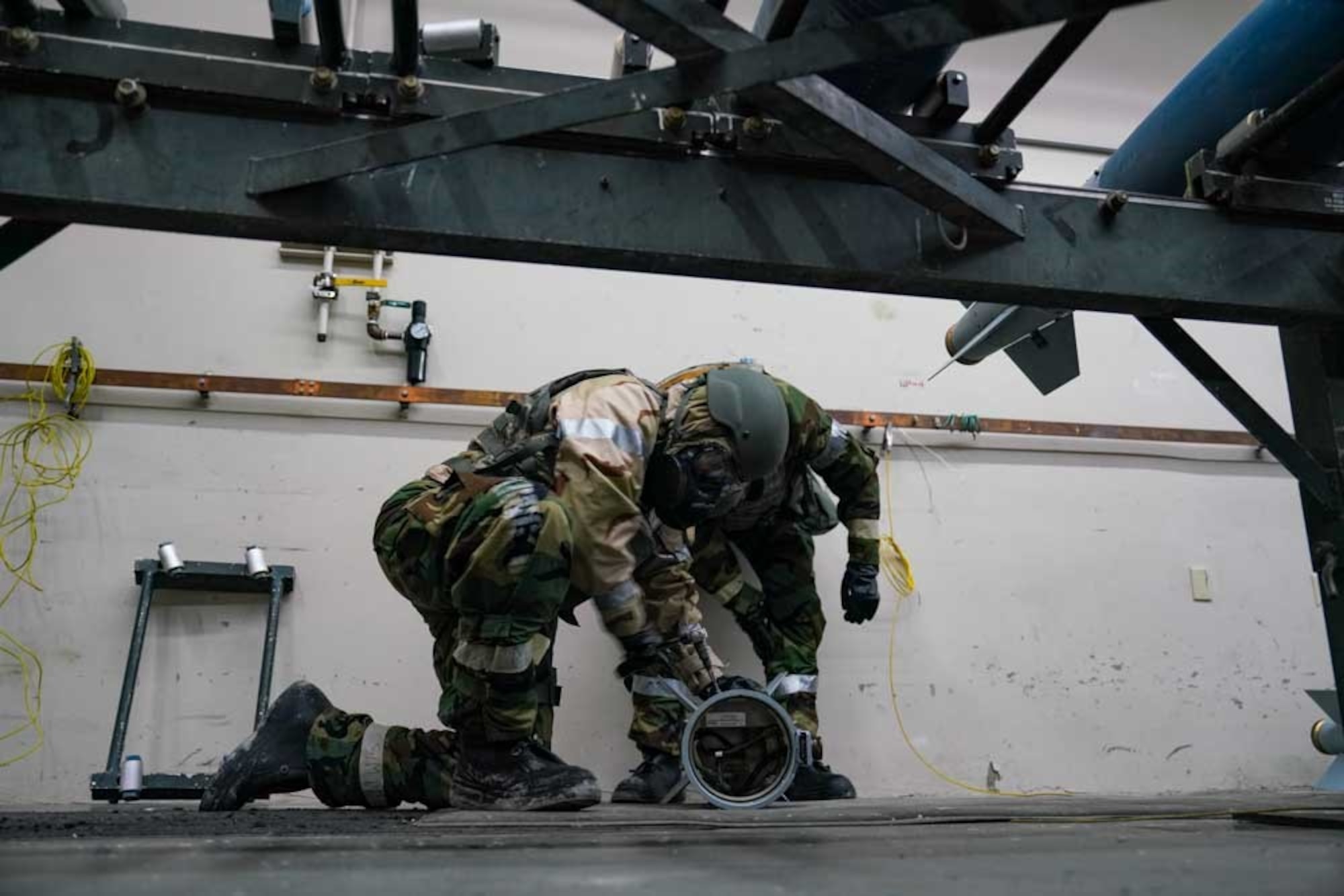 U.S. Air Force Tech. Sgt. Kendra Pace, 25th Maintenance Squadron non-commissioned officer in charge of stockpile surveillance, front, and Airman 1st Class Jacob Taylor,  25th MXS conventional maintenance technician, perform a functional test during exercise Iron Raven  at Creech Air Force Base, Nevada, Nov. 19, 2025.