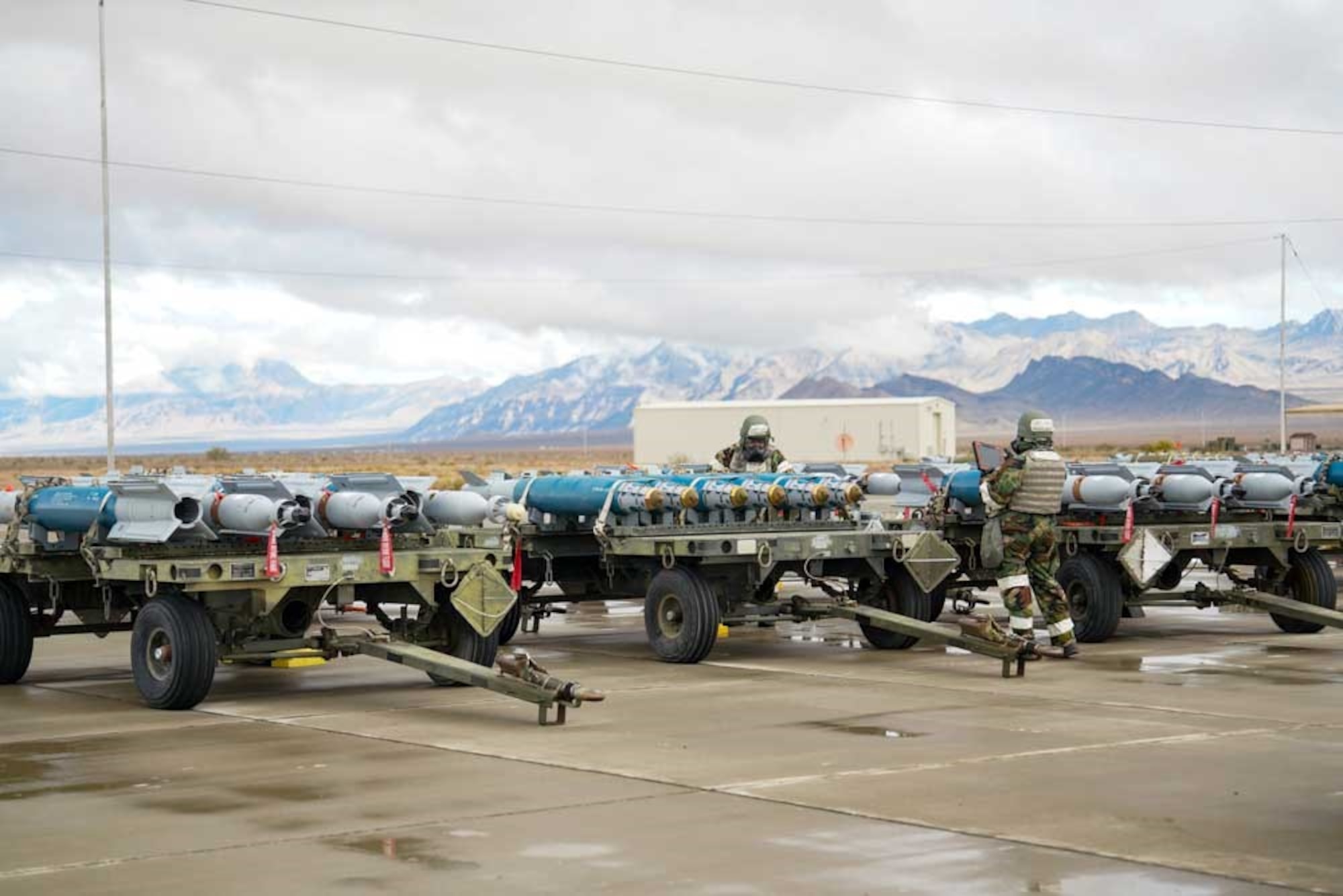From the left, U.S. Air Force Senior Airman Alfred Rice, 25th Maintenance Squadron munitions support equipment maintenance crew chief, and U.S. Air Force Senior Airman Aven Lyanne De La Garza, 25th MXS munitions support equipment maintenance crew chief, conduct a final quality control inspection on inert munitions during exercise Iron Raven at Creech Air Force Base, Nevada, Nov. 19, 2025.