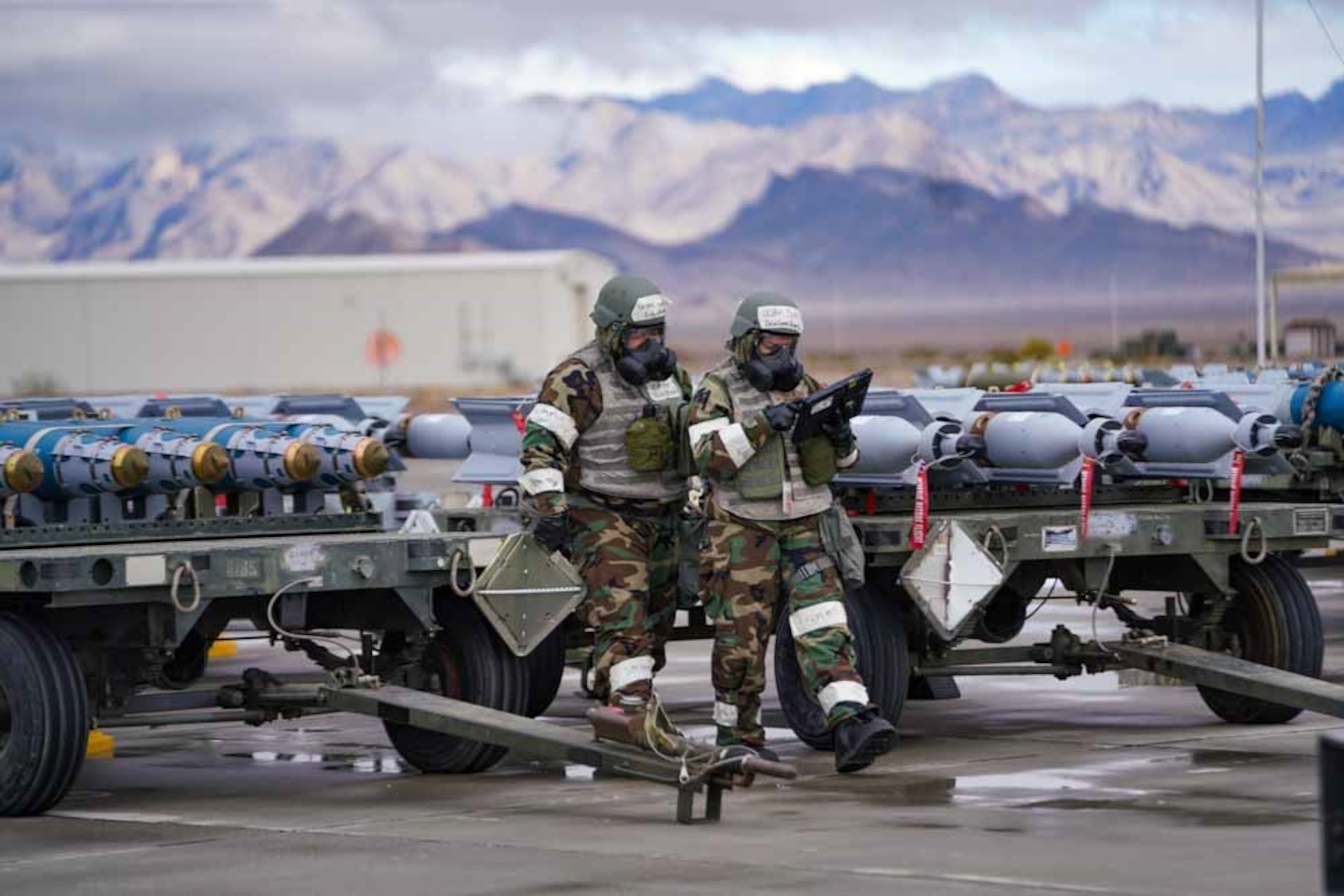From the left, U.S. Air Force Senior Airman Alfred Rice, 25th Maintenance Squadron munitions support equipment maintenance crew chief, and U.S. Air Force Senior Airman Aven Lyanne De La Garza, 25th MXS munitions support equipment maintenance crew chief, review checklists for a pre-towing inspection during exercise Iron Raven at Creech Air Force Base, Nevada, Nov. 19, 2025.