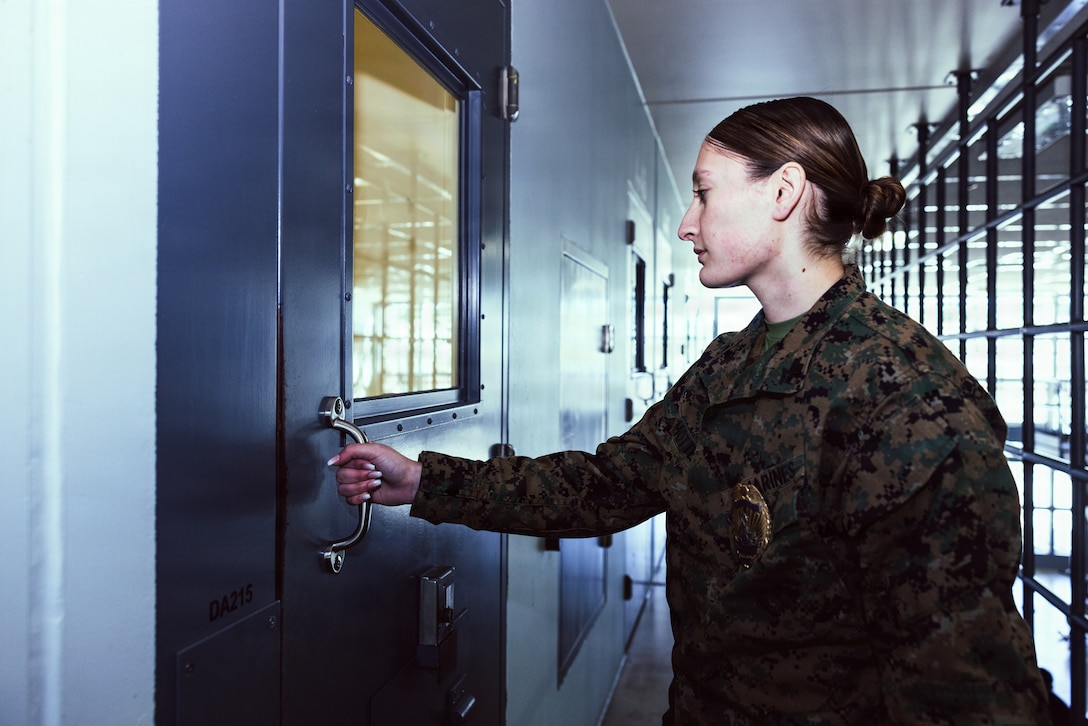 U.S. Marine Corps Lance Cpl. Mayli Motter, a facilities escort with the Marine Corps Installations East-Marine Corps Base (MCB) Camp Lejeune Regional Brig, opens a prison cell door on MCB Camp Lejeune, Dec. 15, 2025. The MCIEAST-MCB Camp Lejeune brig has the capacity to hold 75 prisoners. (U.S. Marine Corps photo by Cpl. Loriann Dauscher)