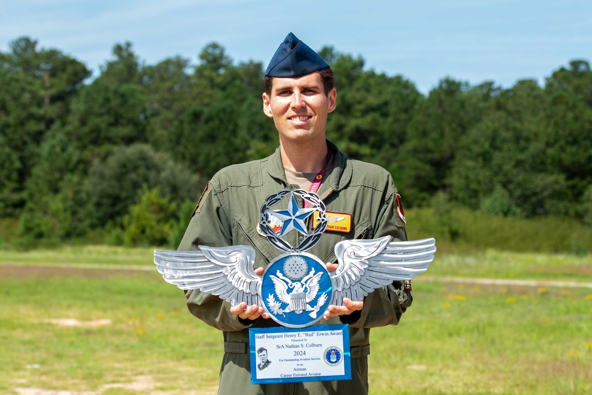 U.S. Air Force Senior Airman Nathan Colburn, 482nd Attack Squadron sensor operator instructor, smiles while holding an award at Shaw Air Force Base, S.C., Aug. 26, 2025.