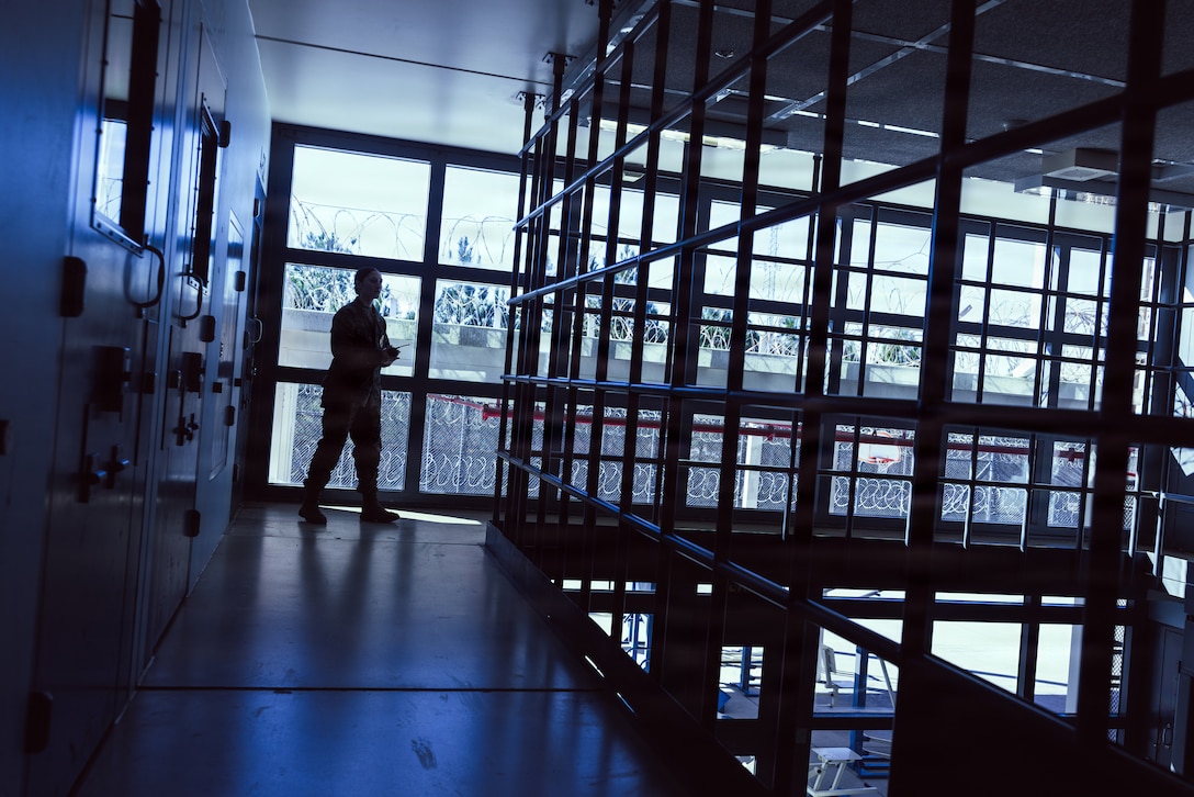 U.S. Marine Corps Lance Cpl. Mayli Motter, a facilities escort with the Marine Corps Installations East-Marine Corps Base (MCB) Camp Lejeune Regional Brig, walks through a catwalk in the brig on MCB Camp Lejeune, Dec. 15, 2025. The Marines carry radios while in the brig and communicate everything with each other, even to have doors unlocked before stepping through. (U.S. Marine Corps photo by Cpl. Loriann Dauscher)