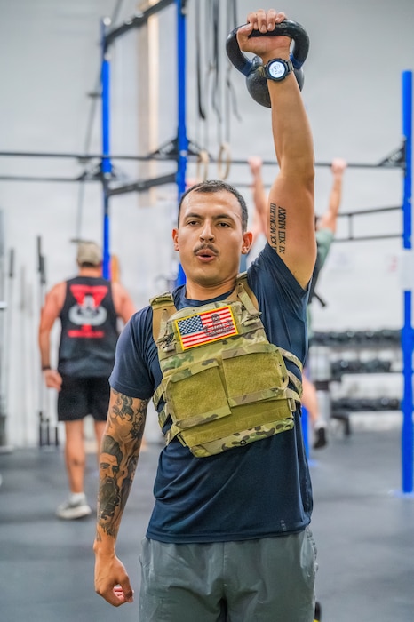 U.S. Air Force Staff Sgt. Jacobo Vasquez, 56th Civil Engineer Squadron explosive ordnance disposal team leader, lifts a kettle bell during an annual memorial workout, Dec. 19, 2025, at Luke Air Force Base, Arizona.