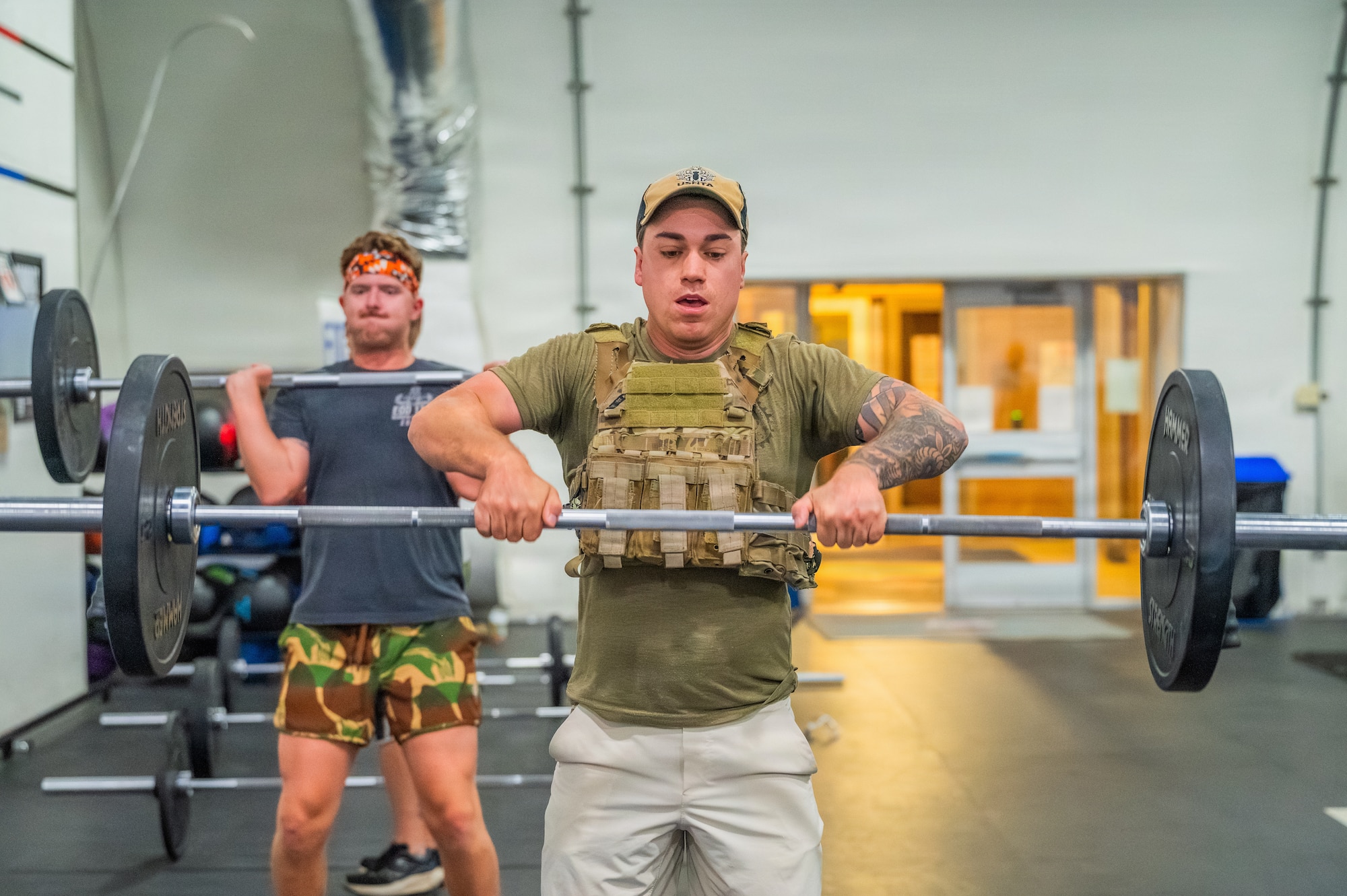 U.S. Air Force Tech. Sgt. Nicholas Frontino (front), 56th Civil Engineer Squadron explosive ordnance disposal team leader, and Senior Airman James Brewer (rear), 56th Civil Engineer Squadron EOD technician, perform a clean during an annual memorial workout, Dec. 19, 2025, at Luke Air Force Base, Arizona.