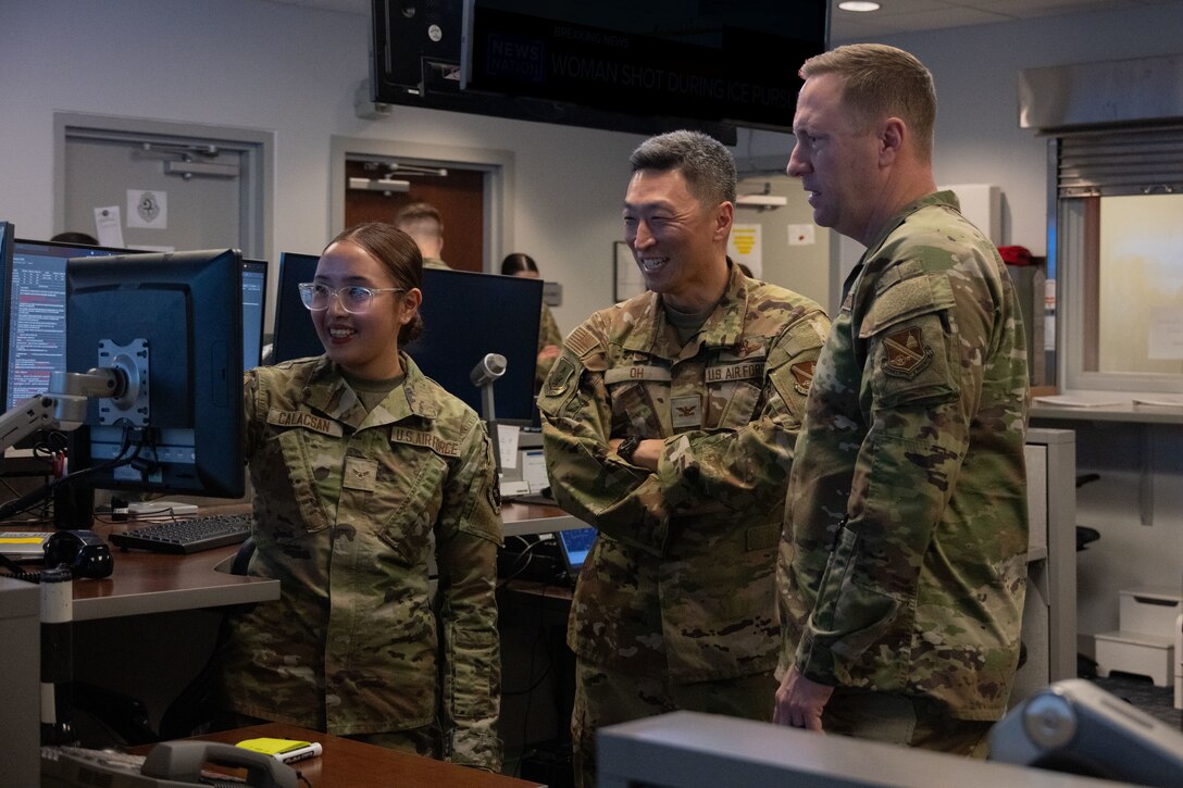 3 people look at a computer screen.