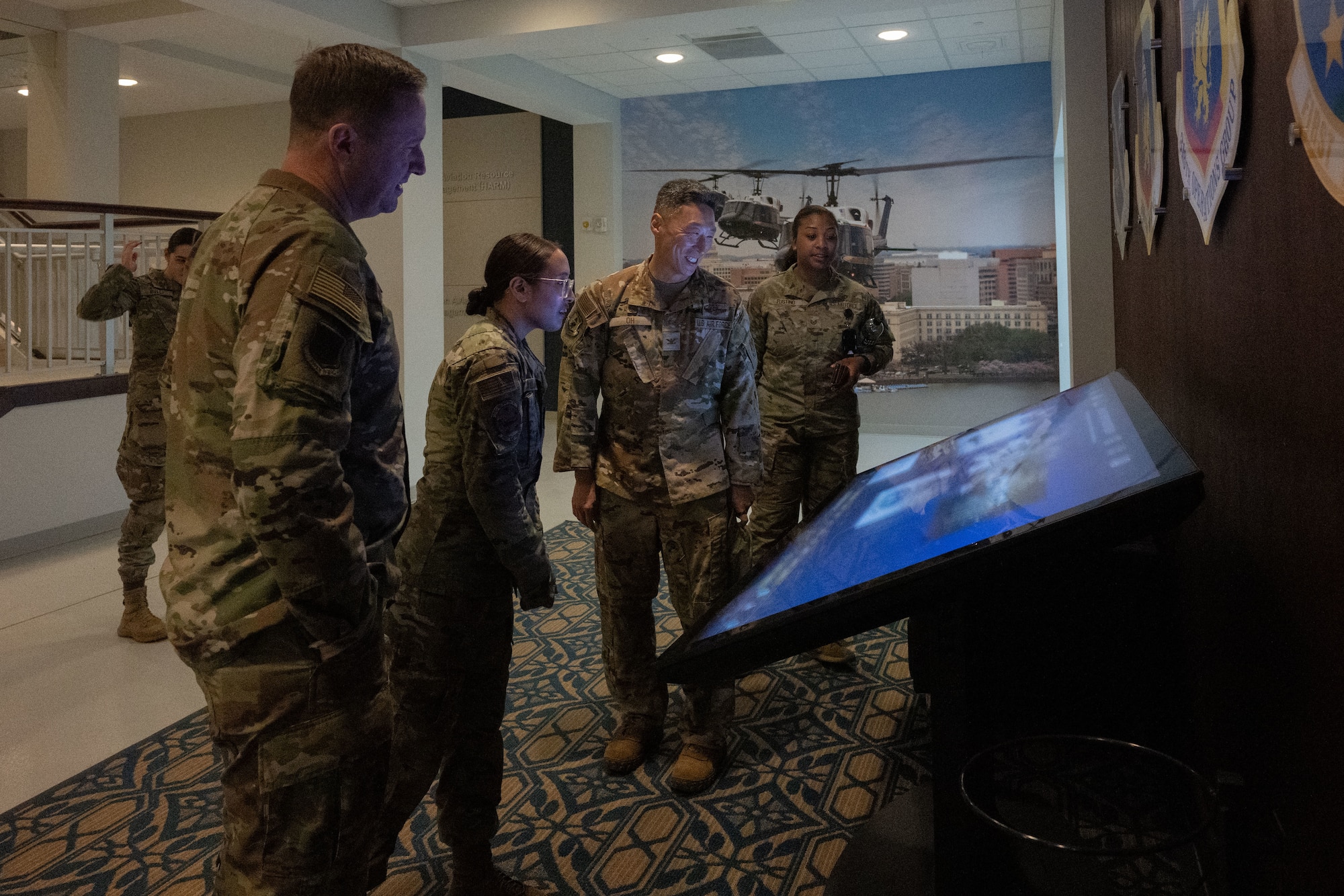 Multiple people look at a digital display.