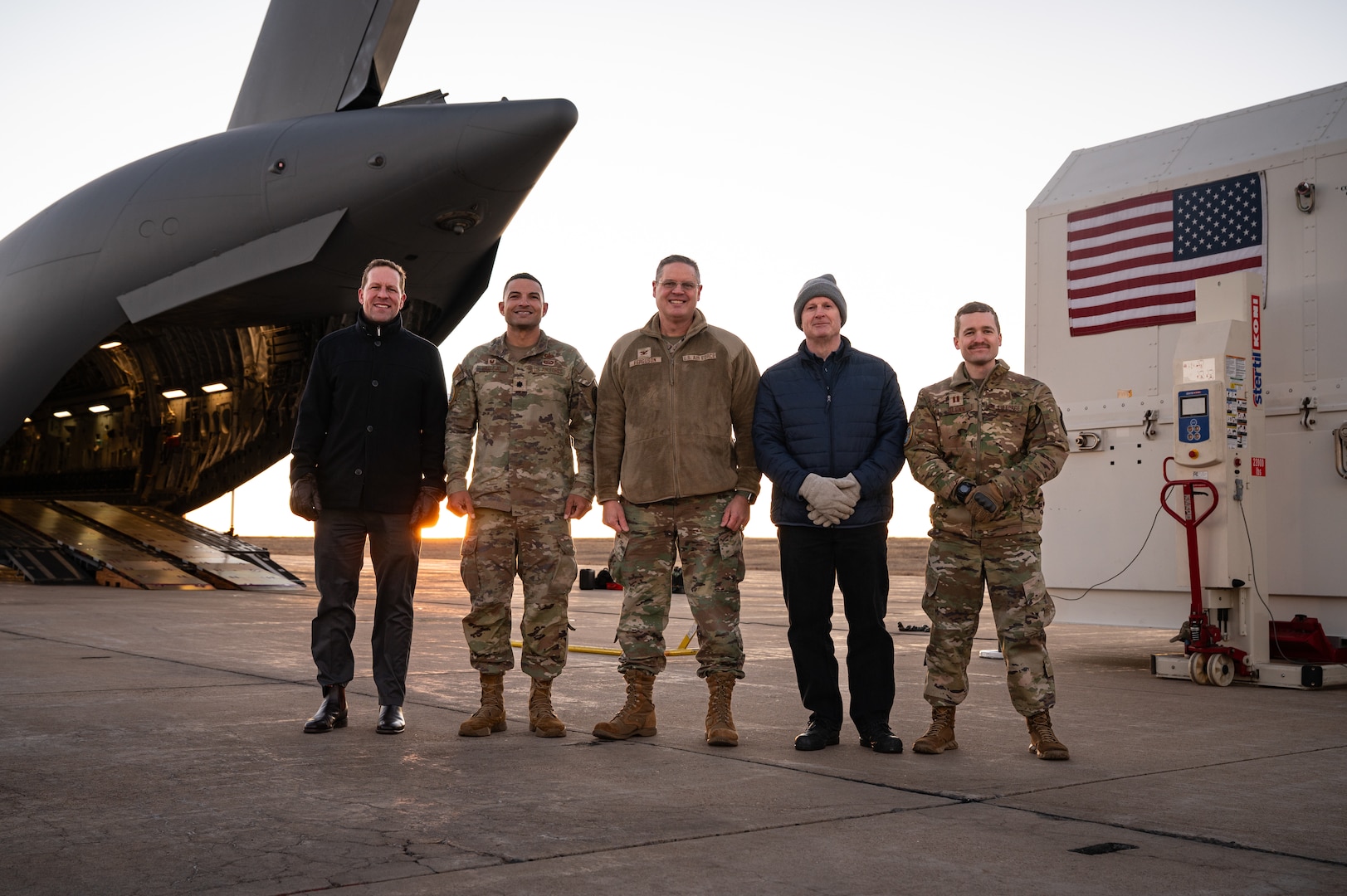A group of five people stand in front of equipment