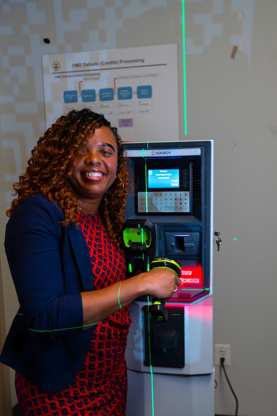 Woman standing next to transaction machine.