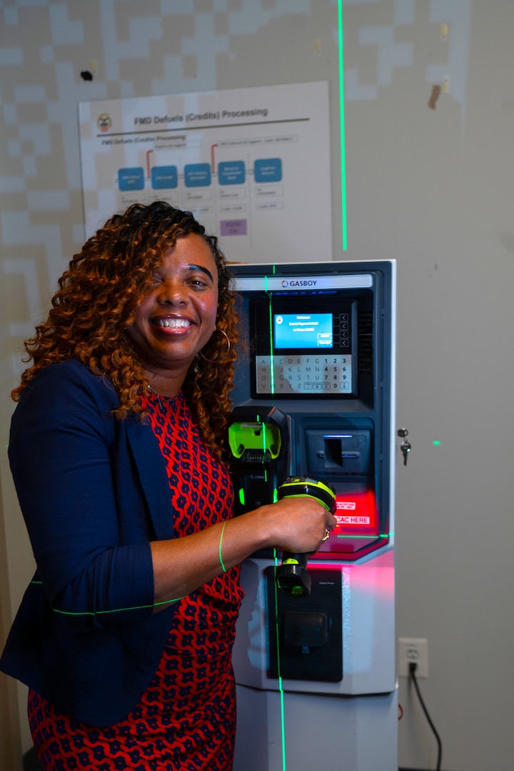 Woman standing next to transaction machine.