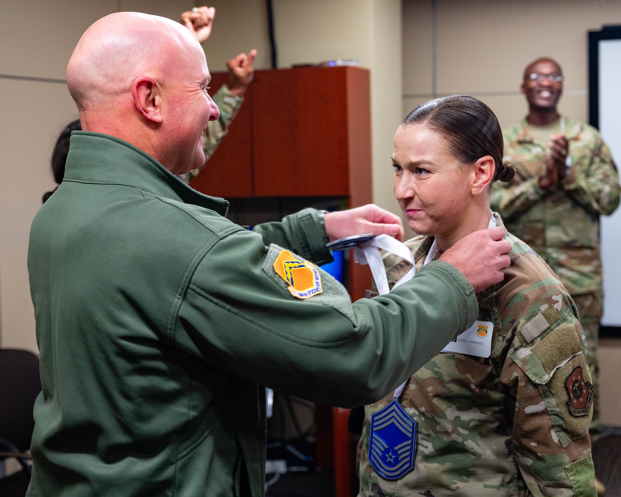 U.S. Air Force Brig. Gen. David Berkland, 56th Fighter Wing commander, gives a medal to Senior Master Sgt. Angela Gonzales, 56th Medical Support Squadron senior enlisted leader, who was selected for promotion to Chief Master Sgt., Jan. 7, 2026, at Luke Air Force Base, Arizona.