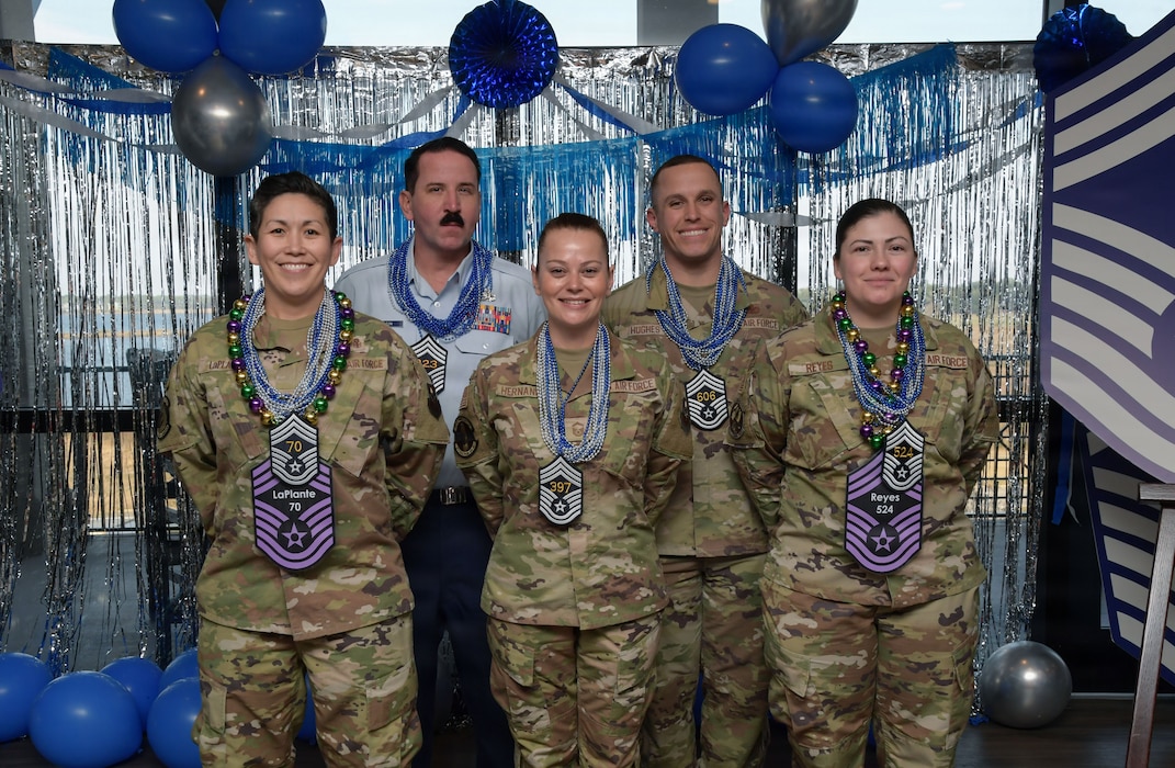 People wearing military uniforms pose for a group photo.