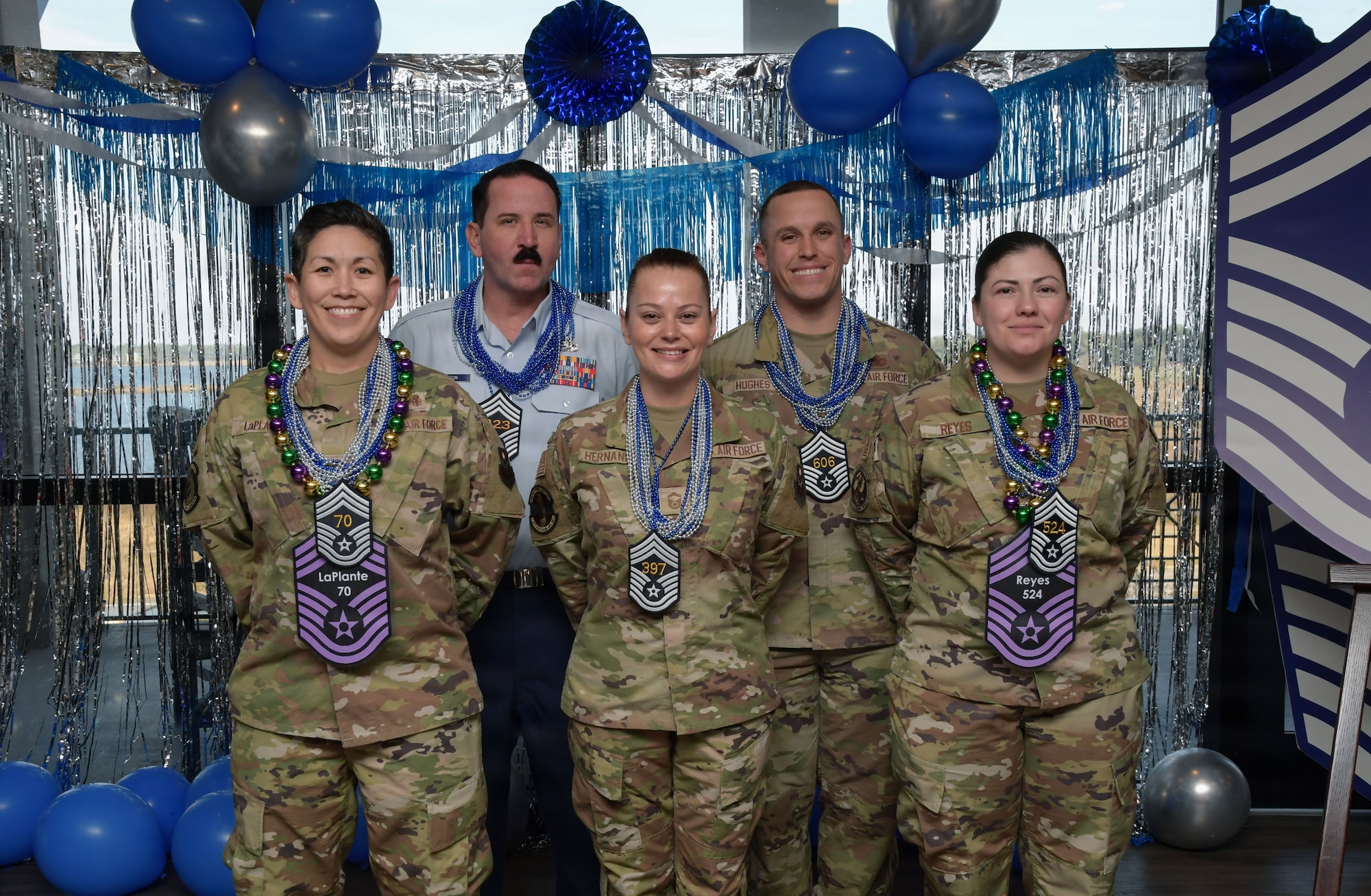 People wearing military uniforms pose for a group photo.