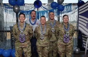 People wearing military uniforms pose for a group photo.