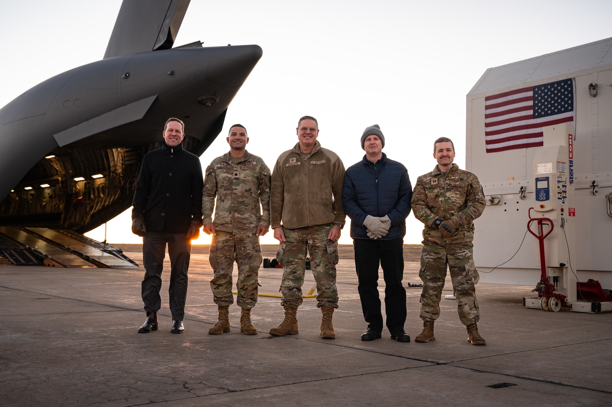 A group of five people stand in front of equipment