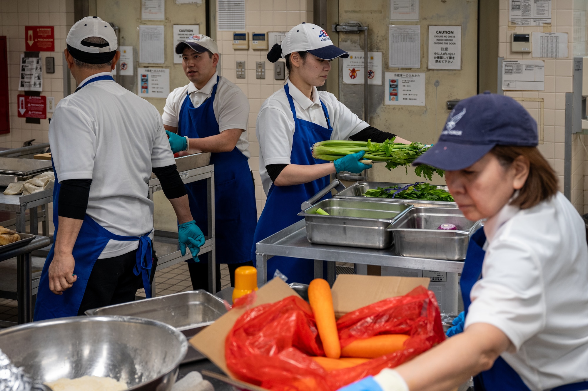 Japanese mass labor contractors from the 718th Force Support Squadron work together during meal preparation at the Marshall Dining Facility at Kadena Air Base, Japan, Jan 8, 2026. Collaboration and teamwork contributed to the dining facility’s selection as a John L. Hennessy Award finalist. (U.S. Air Force photo by Airman 1st Class Francisco Huerta)