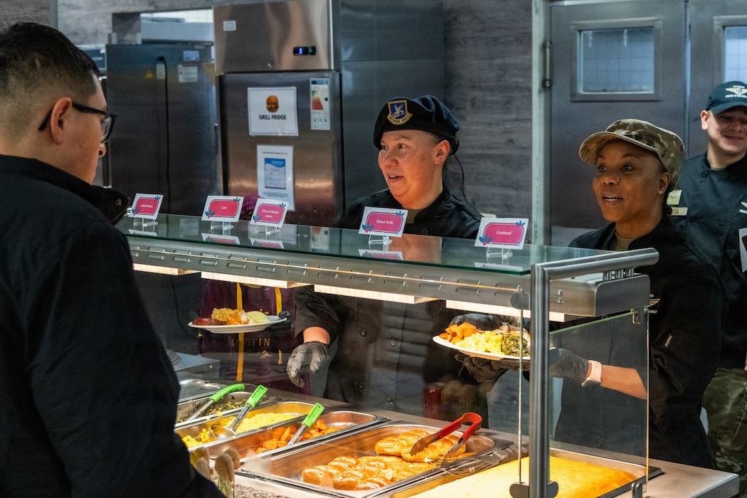 U.S. Air Force Airmen serve food at a buffet.
