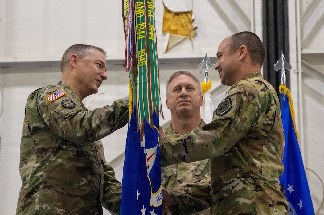 U.S. Army National Guard Maj. Gen. Charles Hausman passes the 131st Bomb Wing guidon to Col. Matthew Howard.