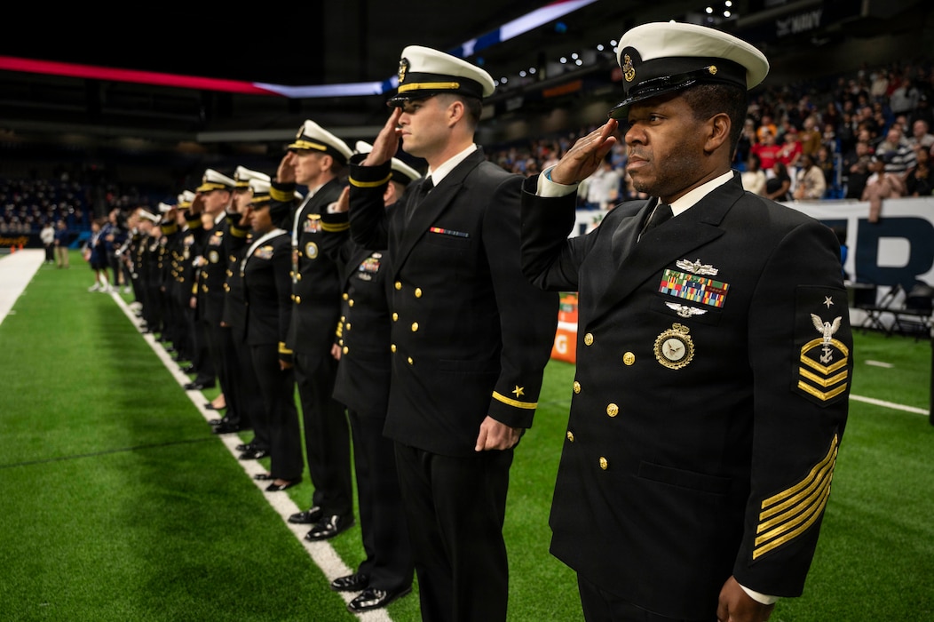 Sailors from Commander, Navy Recruiting Command, salute during the national anthem before the Navy All-American Bowl in San Antonio. The Navy-sponsored event is the nation's premier high school football all-star game.