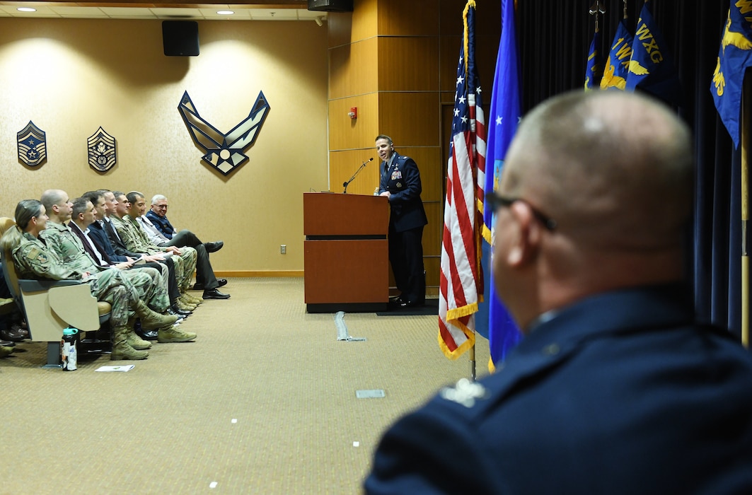 Airmen speak to auditorium during a ceremony.