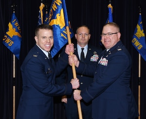 Airmen passes 1st Weather Group guidon to another airmen