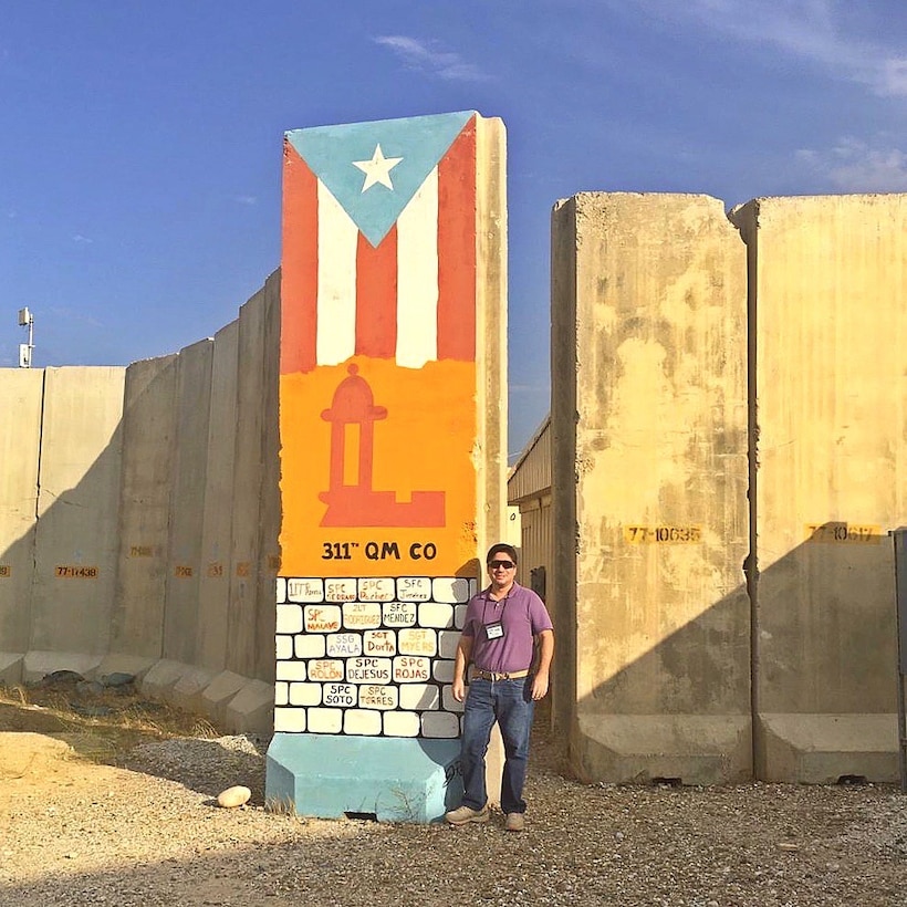 Man standing next to a Puerto Rican unit design.