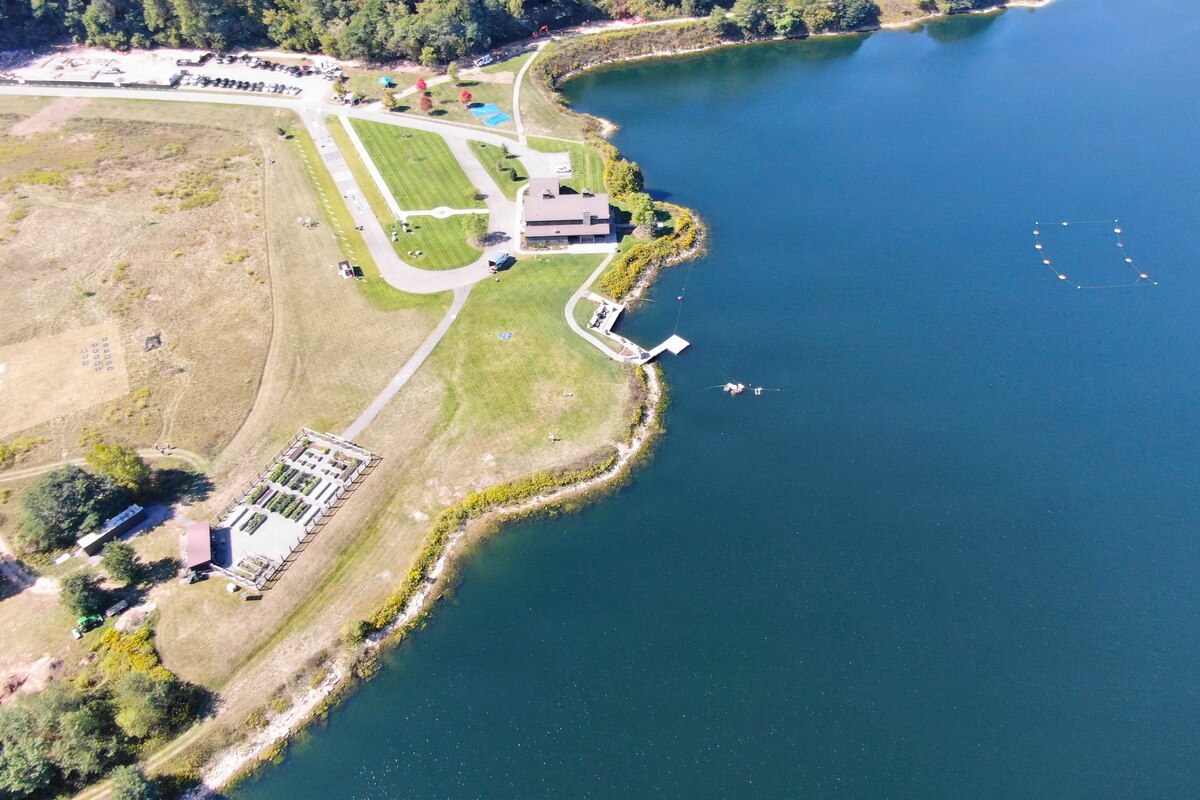 An overhead view shows coastal land flanked by a body of water.