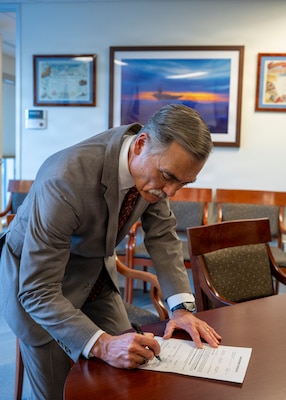 251216-N-IX644-1004 (Dec. 16, 2025) FALLS CHURCH, Va. Dr. Michael B. McGinnis, executive director of U.S. Navy Bureau of Medicine and Surgery, and director of the Navy Medicine Civilian Corps, signs the oath of office paperwork for Genevieve Landers on Dec. 16, 2025. The Navy Medicine Enterprise's 44,000+ talented and ready forces optimize health readiness, deliver quality healthcare, and provide global expeditionary medical support to warfighters. (U.S. Navy photo by Mass Communication Specialist 2nd Class Sasha Ambrose)