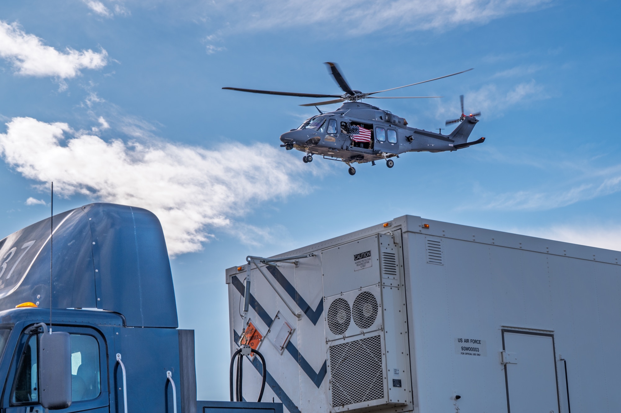 A helicopter flying over a semi trailer