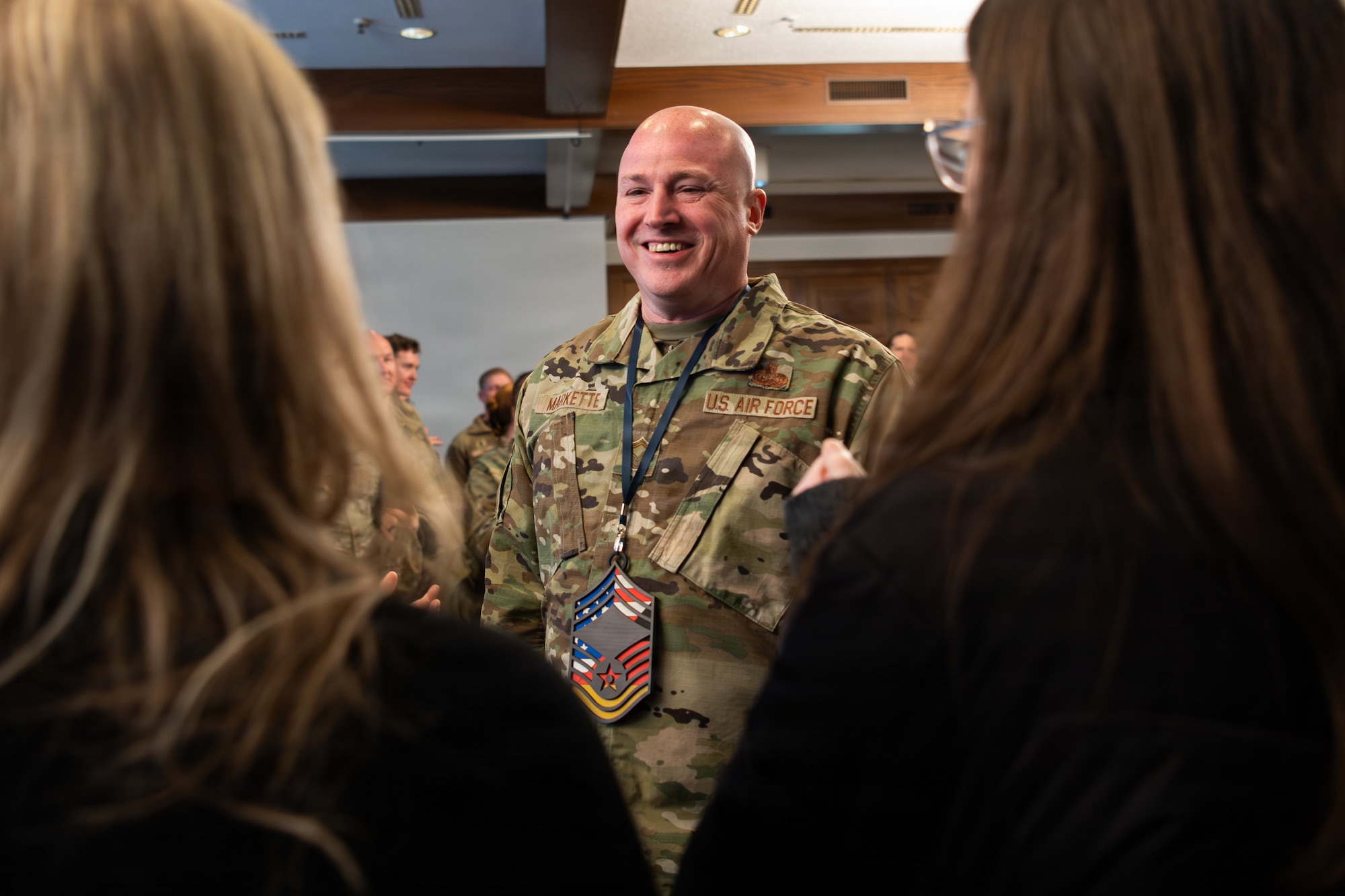 U.S. Air Force Senior Master Sgt. Anthony Markette, 86th Communications Squadron operations flight chief, smiles at his family after being selected to promote to chief master sergeant at Ramstein Air Base, Germany, Jan. 8, 2026.