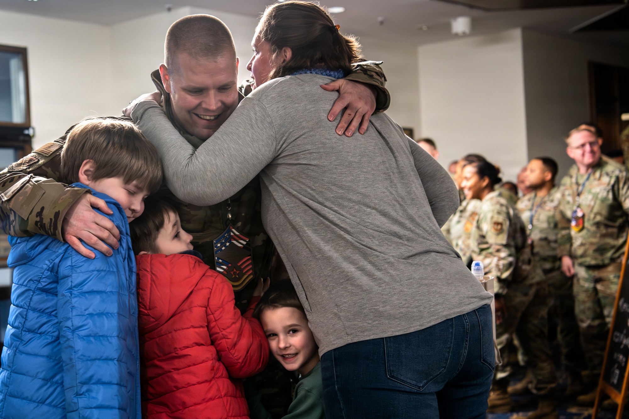 U.S. Air Force Senior Master Sgt. Aaron Clark, 603rd Air Operations senior enlisted leader, hugs his family after being selected to promote to chief master sergeant at Ramstein Air Base, Germany, Jan. 8, 2026.