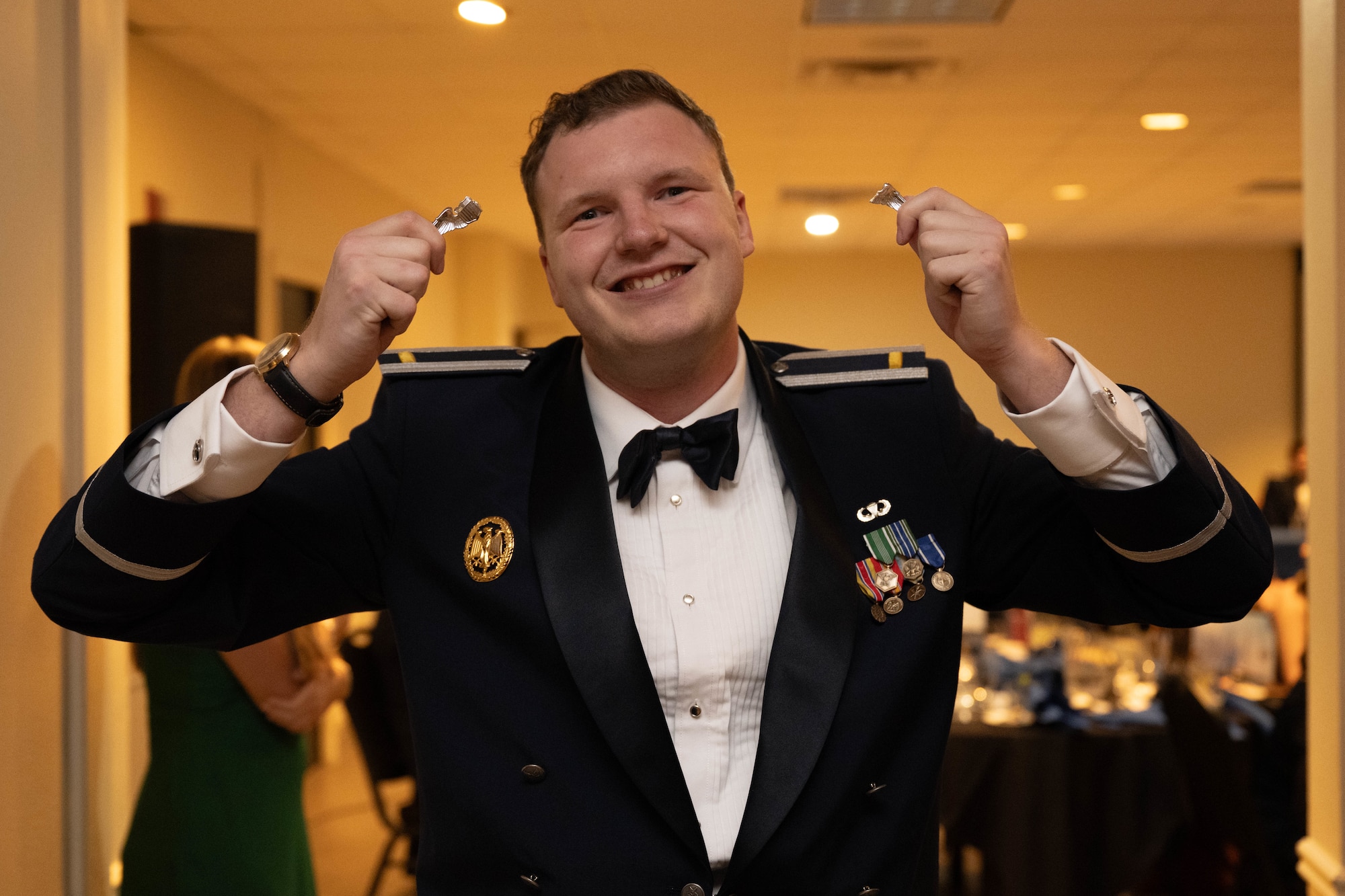 U.S. Air Force 2nd Lt. Joseph Fox, 47th Student Squadron student pilot, holds up their broken silver wings during a pilot graduation ceremony at Laughlin Air Force Base, Texas, Jan. 8, 2026. The breaking of silver wings is a tradition dating back to the U.S. Army Air Corps where a pilot's first wings are not to be worn but broken and given to a loved one. (U.S. Air Force photo by Airman 1st Class Darryl Keith)