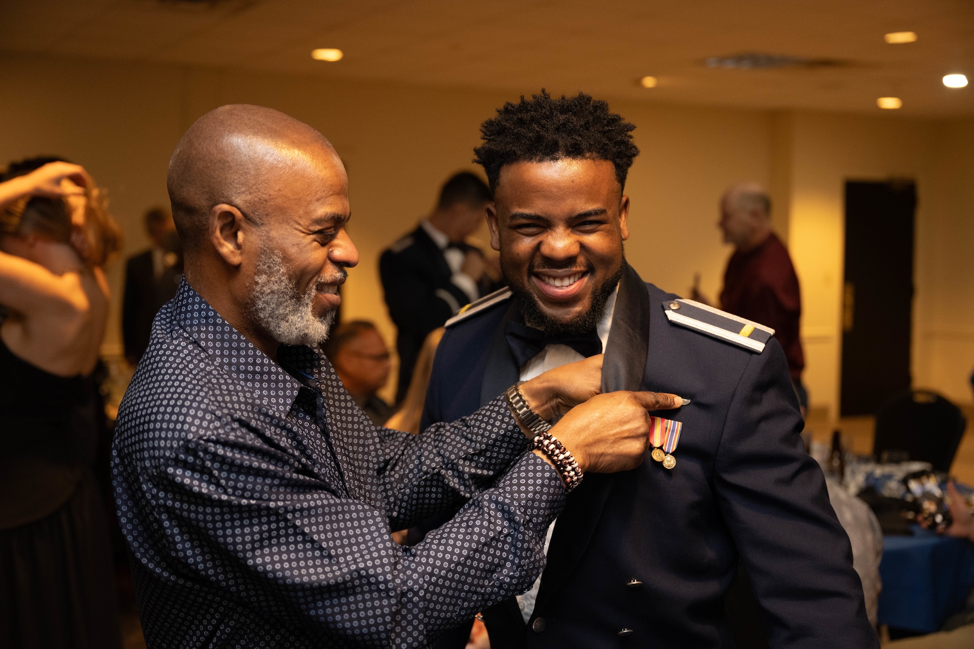 A loved one pins the silver wings onto U.S. Air Force 2nd Lt. Abdulmalik Ariyo, 47th Student Squadron student pilot, during a pilot graduation at Laughlin Air Force Base, Texas, Jan. 8, 2025. Graduating pilots were awarded silver wings as a symbol of successfully completing Undergraduate Pilot Training. (U.S. Air Force photo by Airman 1st Class Darryl Keith)