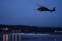 Carrying U.S. Coast Guard members of the Maritime Security Response Team, a 210th Rescue Squadron HH-60G Pave Hawk combat search and rescue helicopter conducts joint hoist training Jan. 23, 2023, at Coast Guard Station Kodiak.