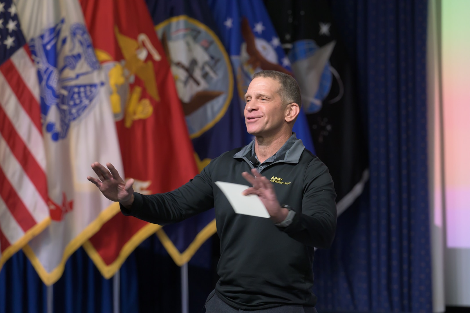 A man stands on a stage as he addresses a crowd
