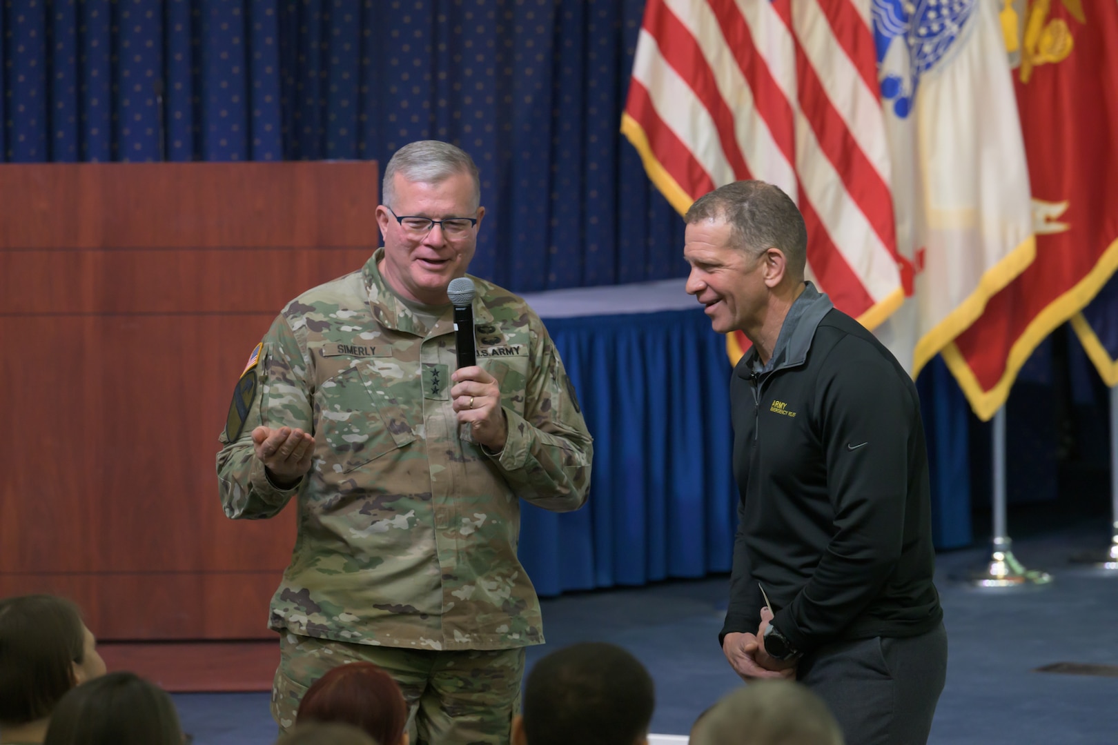 Two men stand in front of a crowd.