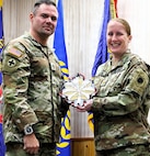 Illinois Army National Guard Sgt. 1st Class Michael Servough presents a gift to Maj. Jennifer Hillyer on behalf of the soldiers she served with during her retirement ceremony on Jan. 9.