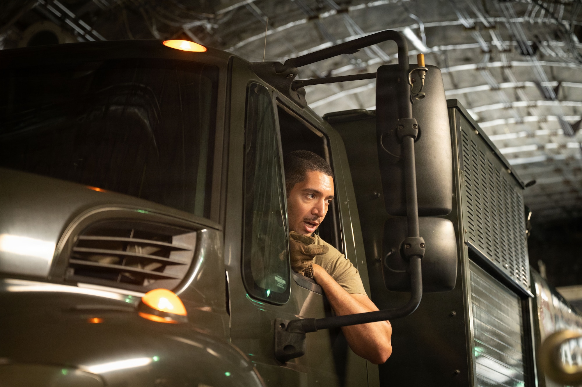 An Airman drives a vehicle out of a C-17 cargo plane.