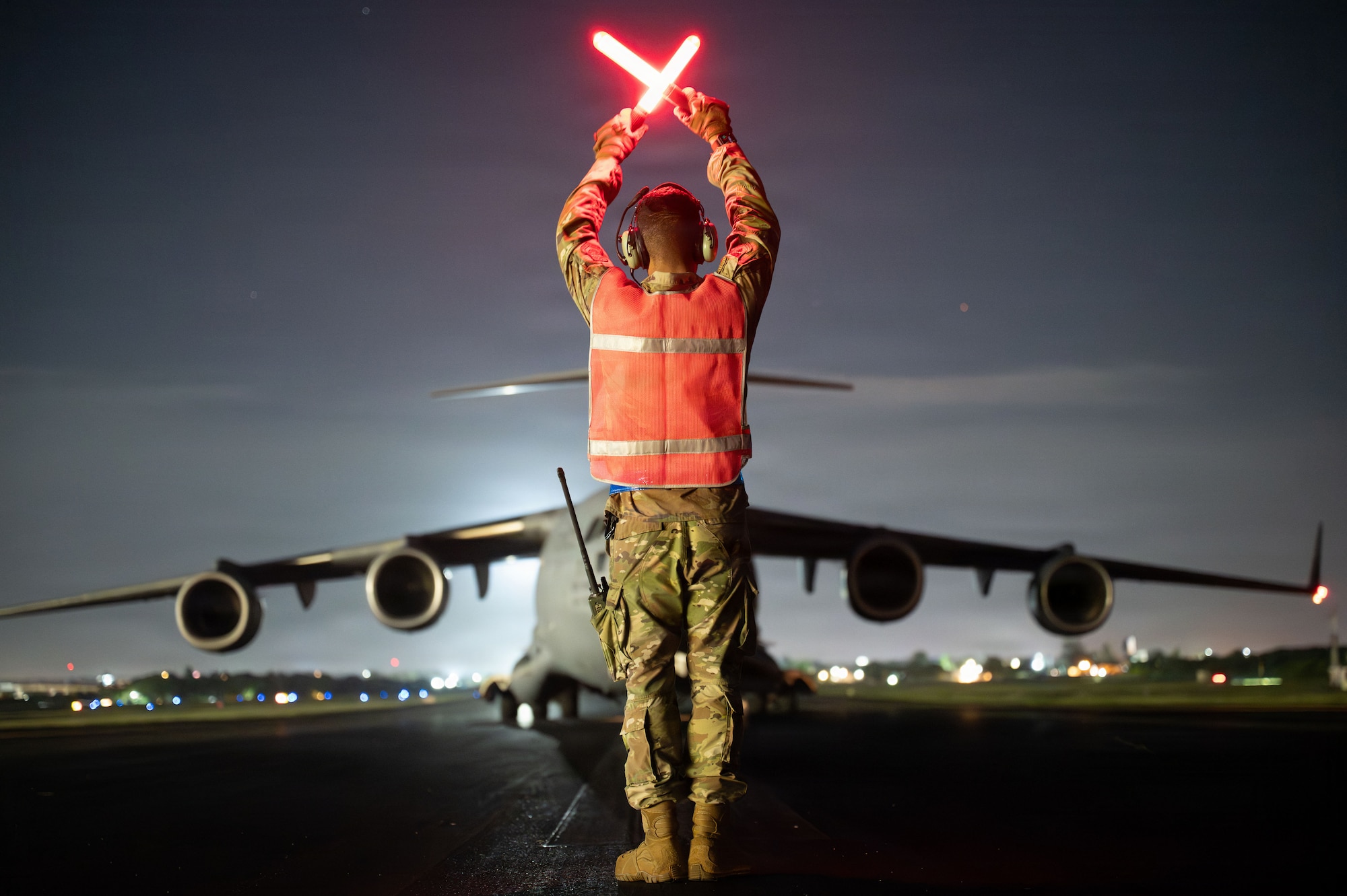 An Airman signals a C-17 to park.