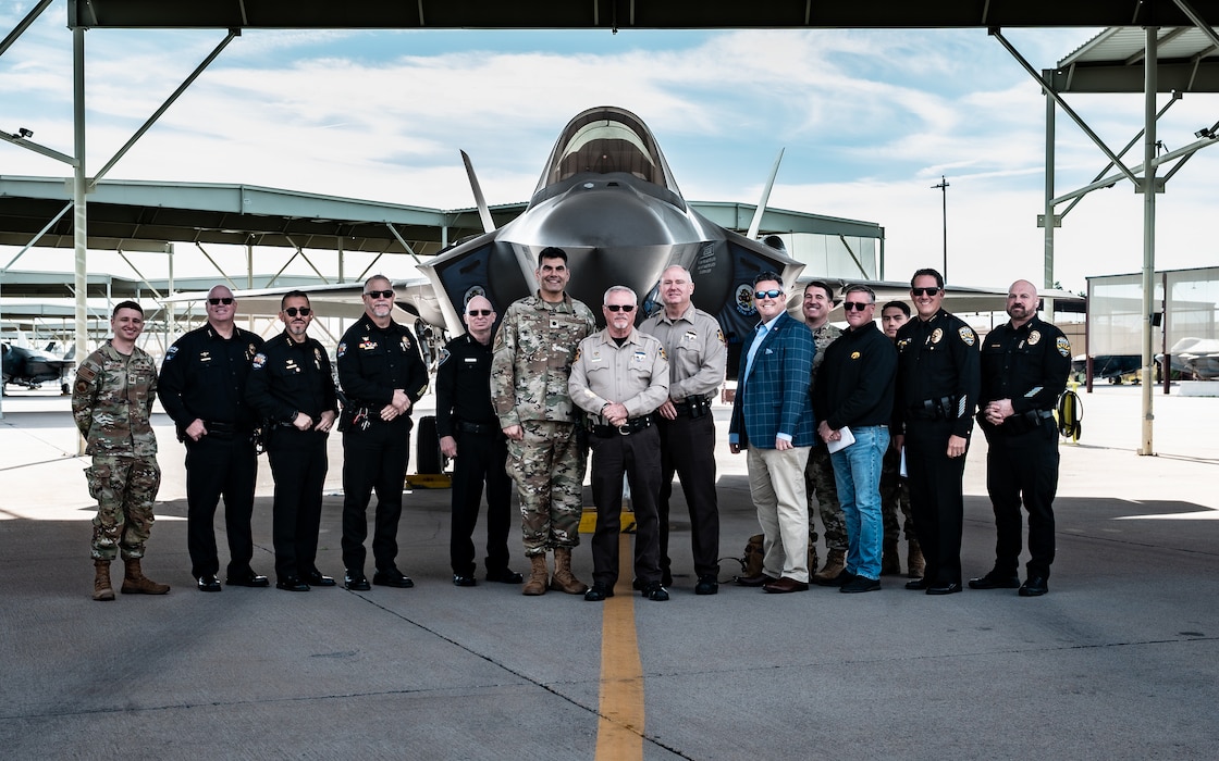 A delegation of local Police Chiefs poses in front of an F-35A Lightning II